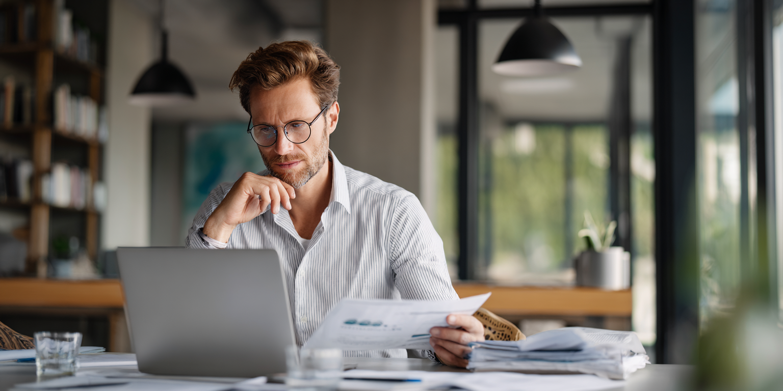 Professional preparing for AI job interview with laptop and technical documentation